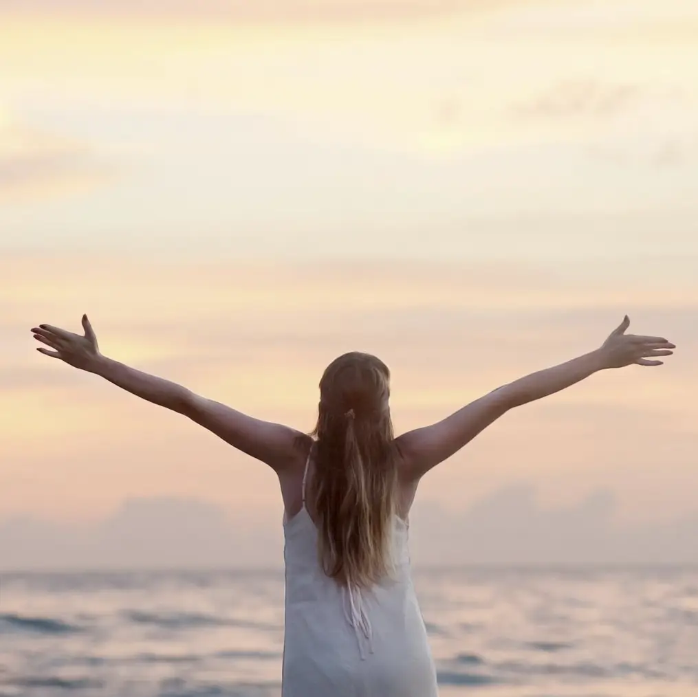 Woman open arms ocean in front of her